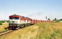Na dalším záběru dotváří vápencový vlak Pn 65780 krajinu po odjezdu ze  stanice Unhošť. Dne 11. srpna 2003 byly v čele stroje 751.028+751.219.