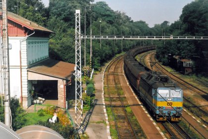 363.121 projíždí 3. srpna 2002 v čele uhelného vlaku dnes již k nepoznání přestavěnou stanici Strančice.