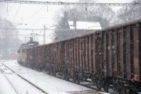 Černouhelný vlak projíždí vánicí stanicí Jindřichův Hradec 1. prosince 2010. V čele "laminátky" 240.057+108.